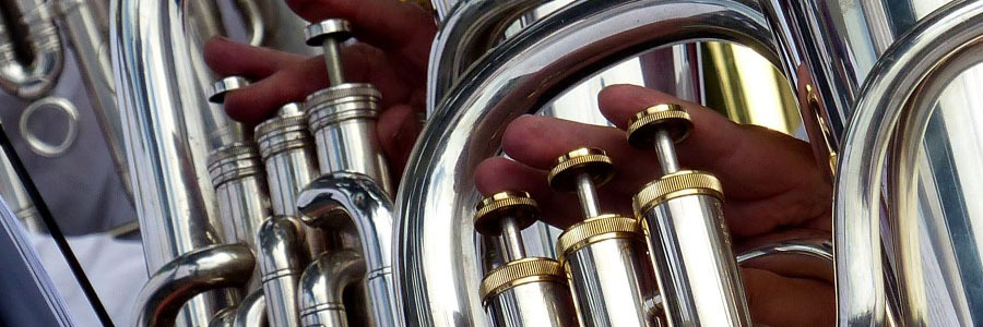 closeup picture of silver and brass valves being played by disembodied hands